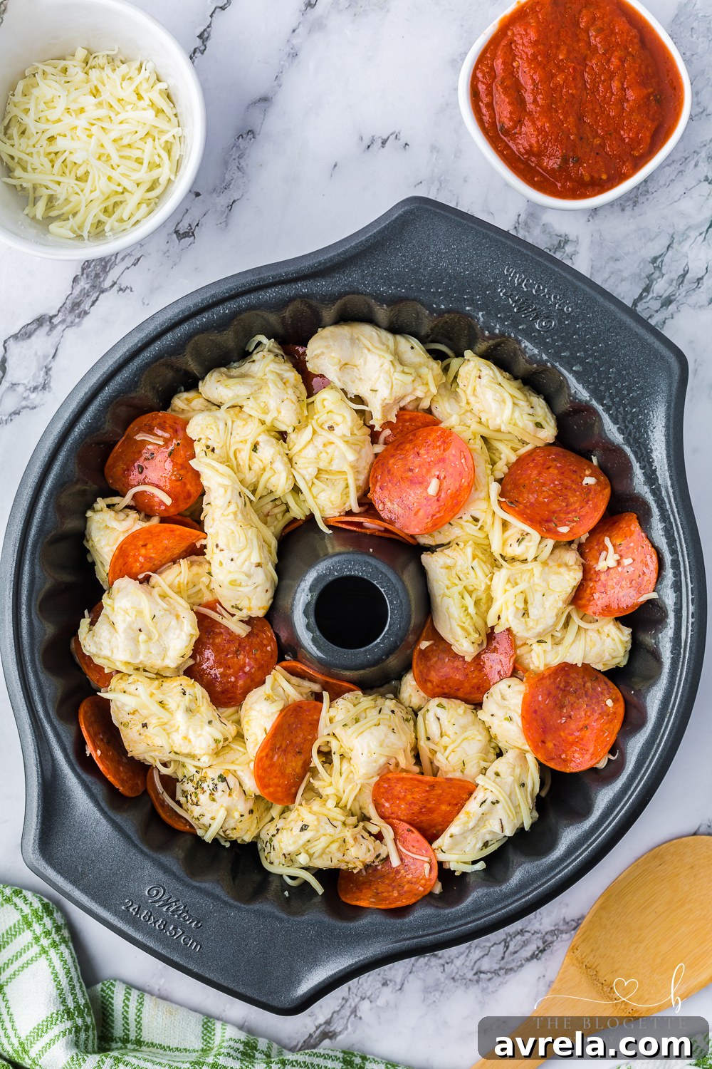 Cheesy Pizza Pull-Apart Bread 6 Placing the mixed pizza bread ingredients into a bundt pan.