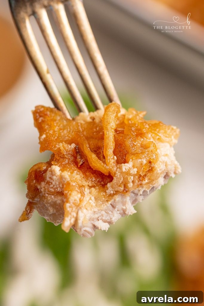 French Onion Pork Chops on a plate with a side dish, ready to be enjoyed.