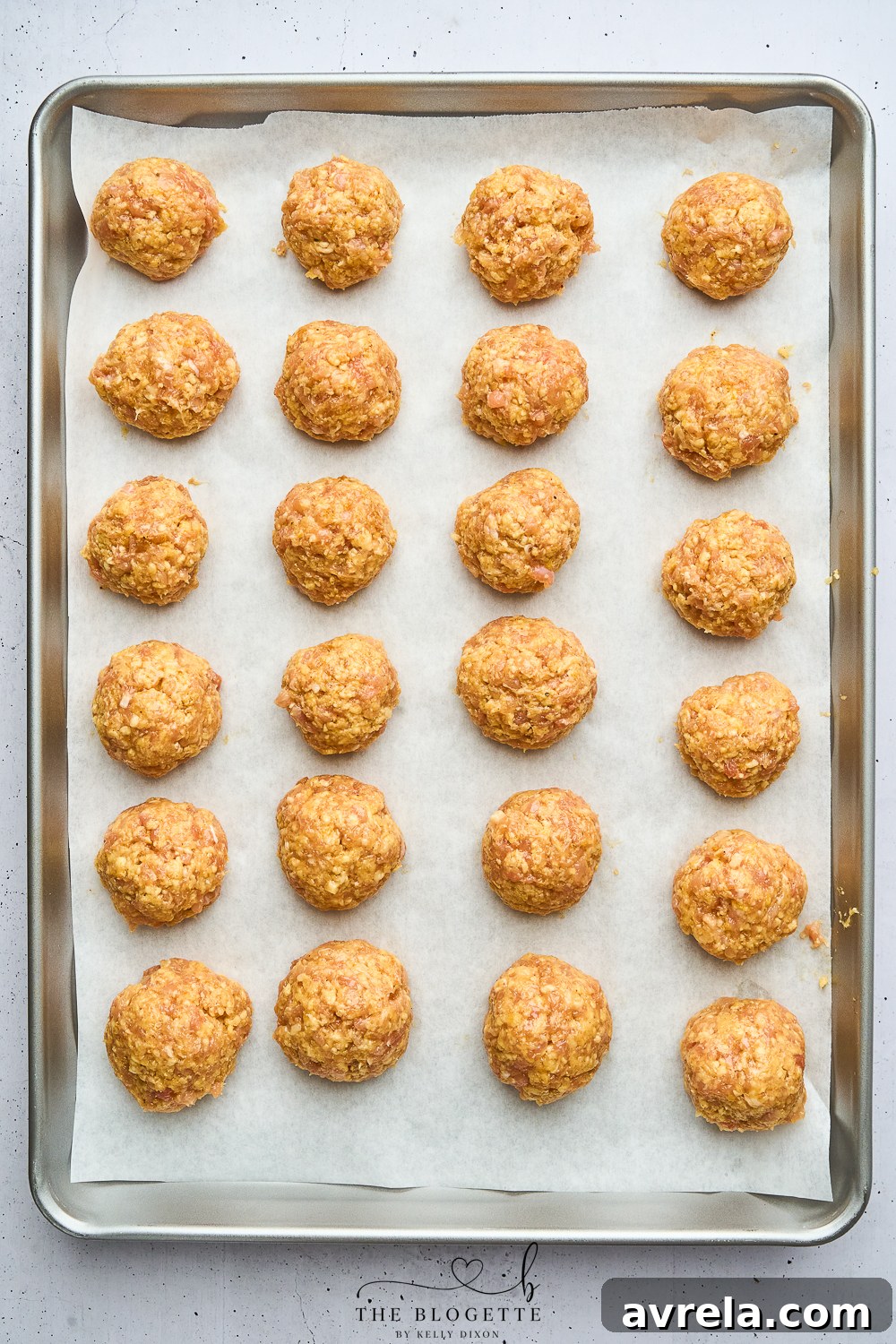 Velvety Makhani Sauce 6 Baked chicken meatballs on a parchment-lined baking sheet, golden and ready.