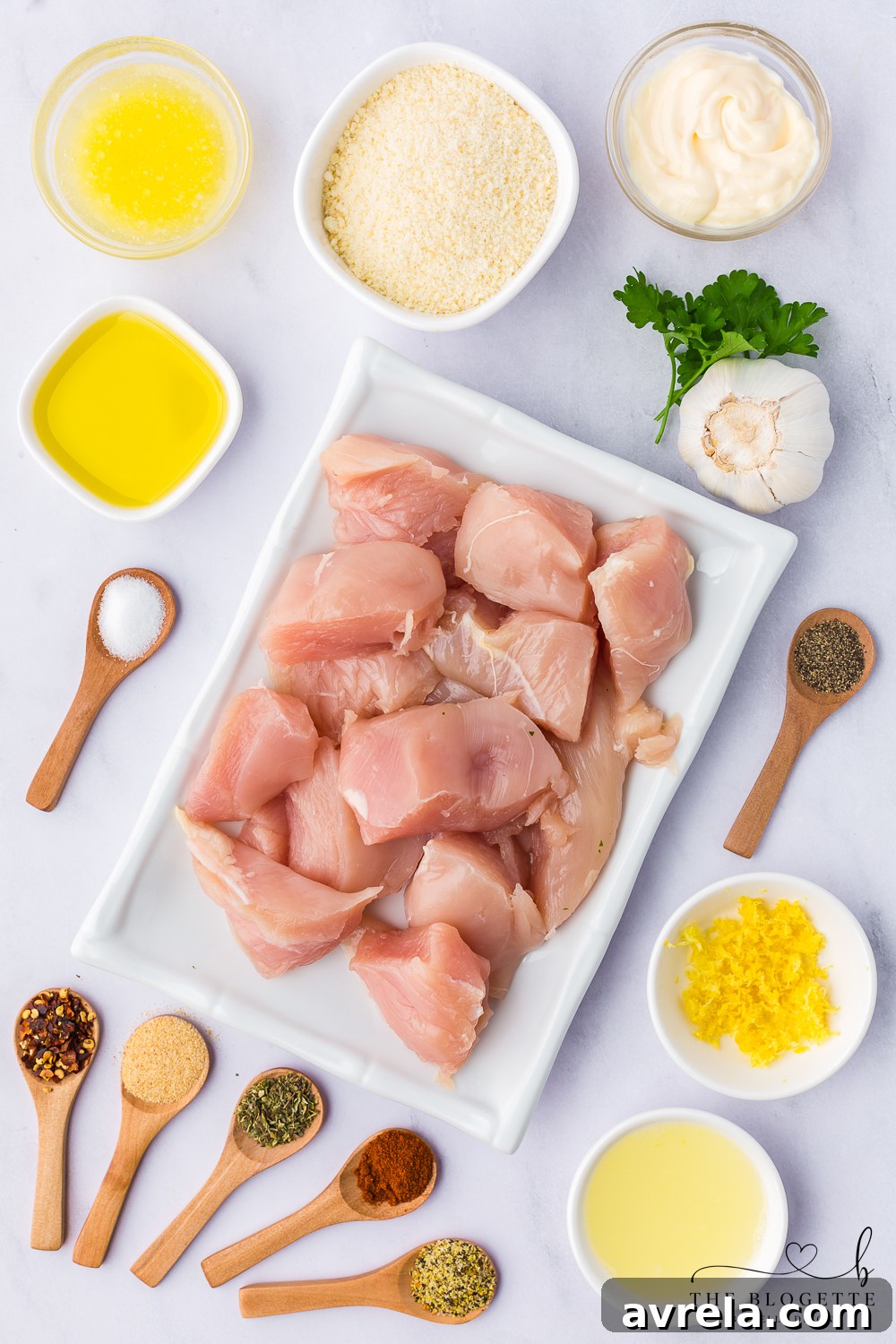A vibrant selection of ingredients including fresh chicken, herbs, garlic, lemons, and various spices, all laid out beautifully for a delicious recipe.