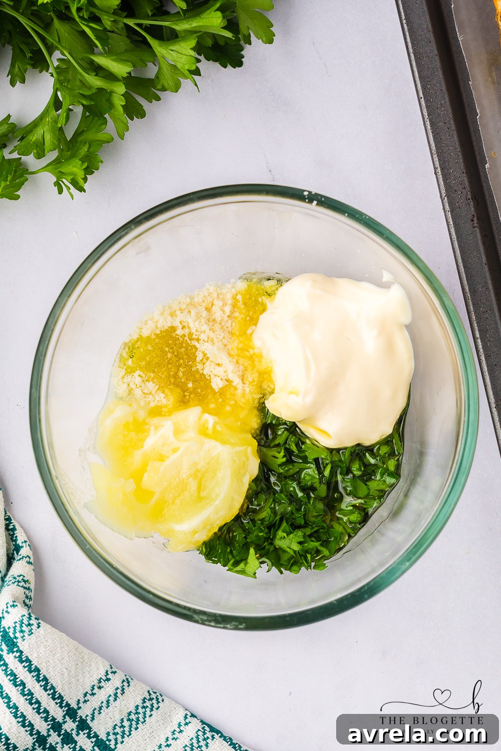 A small bowl containing a creamy, rich garlic sauce, prepared with roasted garlic, mayonnaise, melted butter, and fresh parsley, blended until smooth.