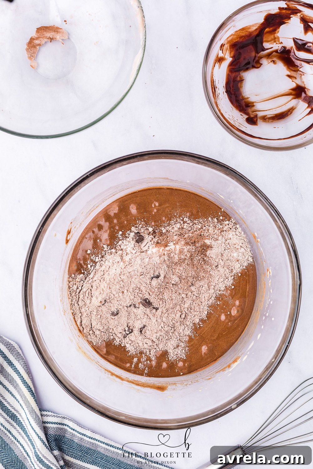 Gently folding melted chocolate mixture into the whipped egg and sugar mixture with a rubber spatula.