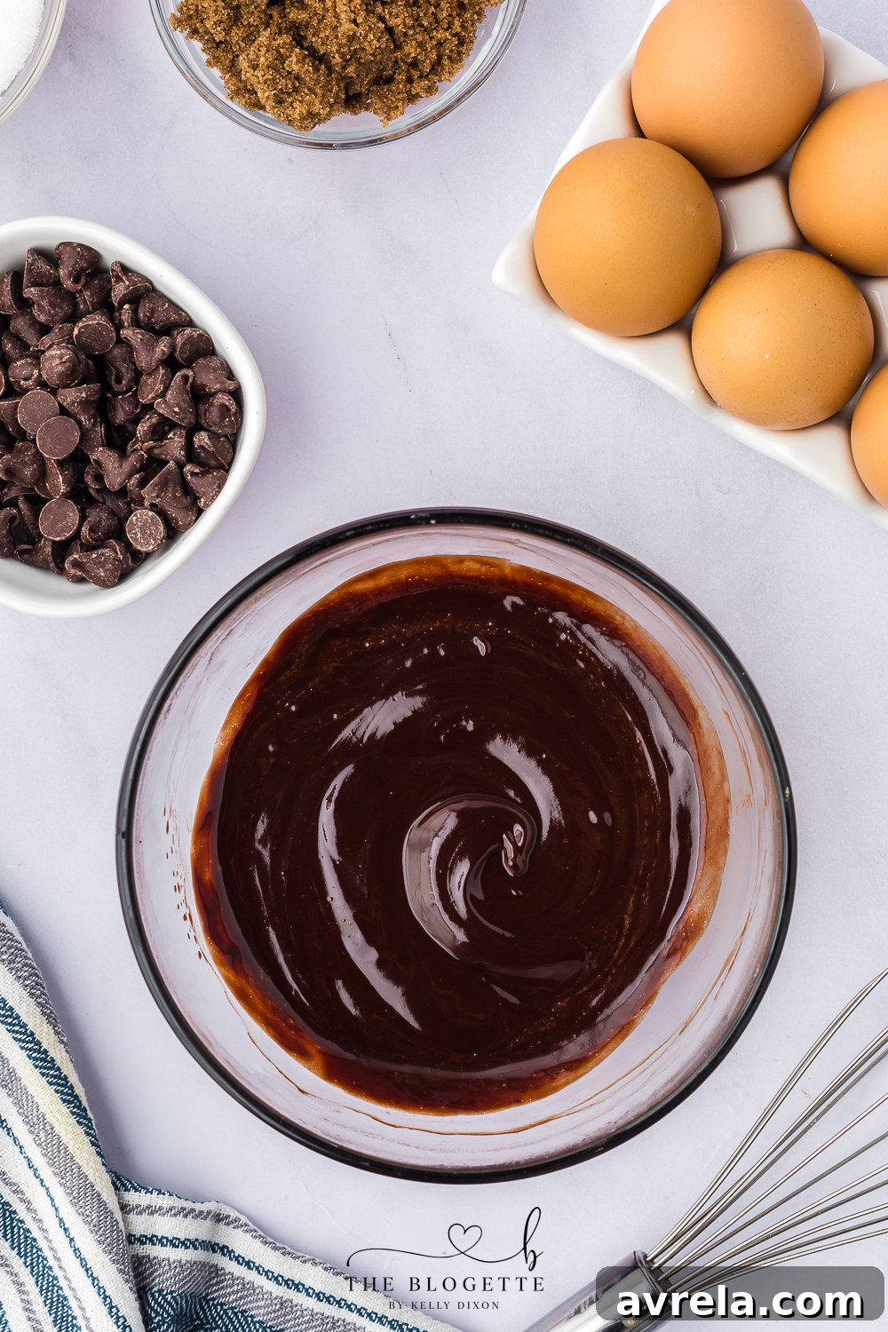 Melted chocolate and butter mixture being stirred in a bowl, smooth and glossy