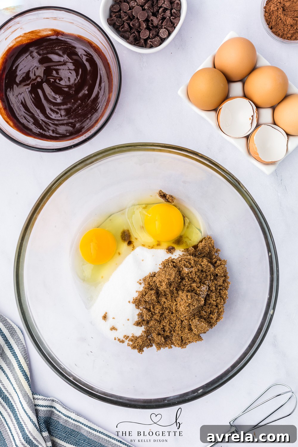 Granulated sugar, brown sugar, and eggs being beaten with an electric mixer until fluffy.