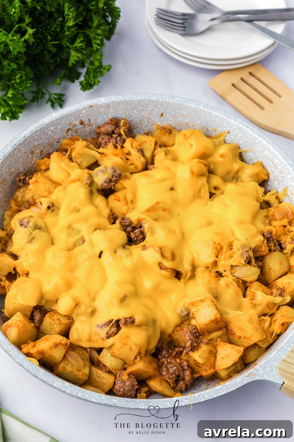 Skillet Sloppy Joes 3 Golden brown seasoned potatoes and melted sharp cheddar cheese topping a hearty sloppy joe mixture in a skillet.