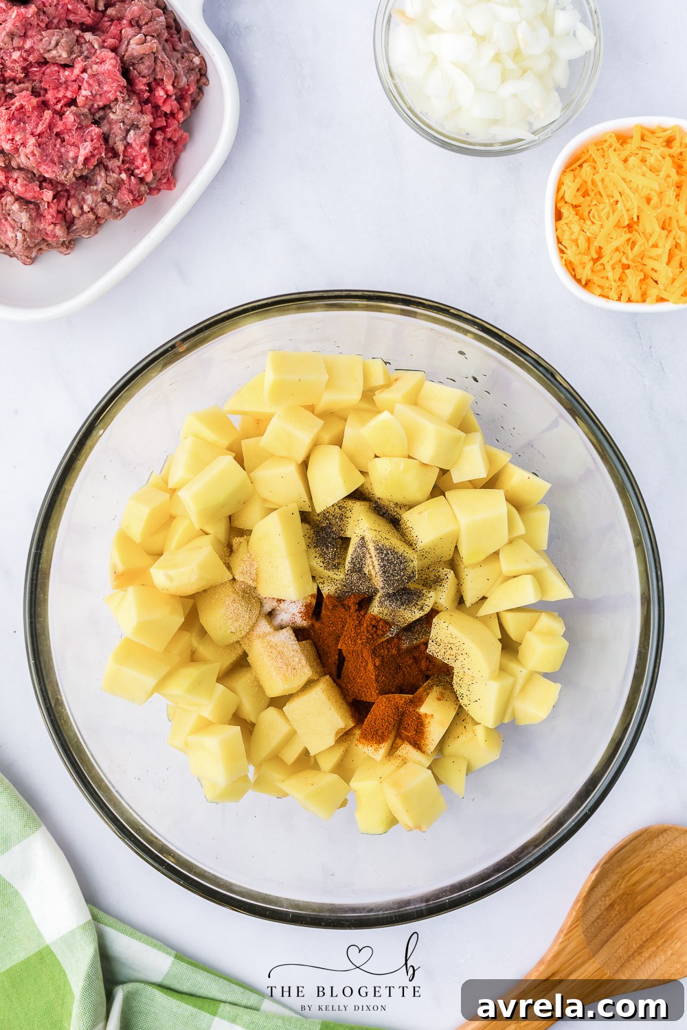 Skillet Sloppy Joes 5 Tossing cubed potatoes with olive oil and spices in a large bowl, preparing them for baking.