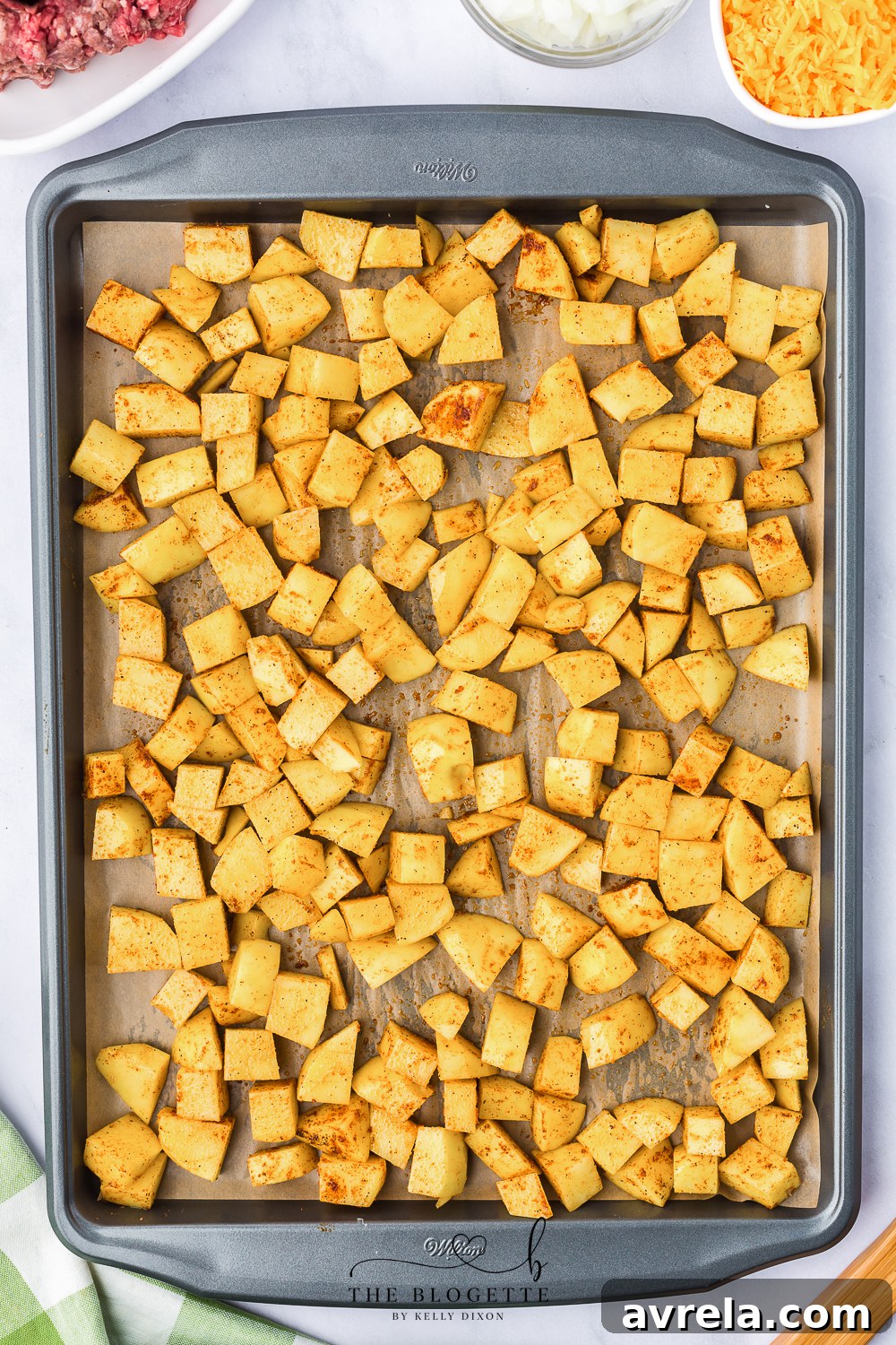 Skillet Sloppy Joes 6 Cubed, seasoned potatoes baking on a parchment-lined sheet, turning golden brown.