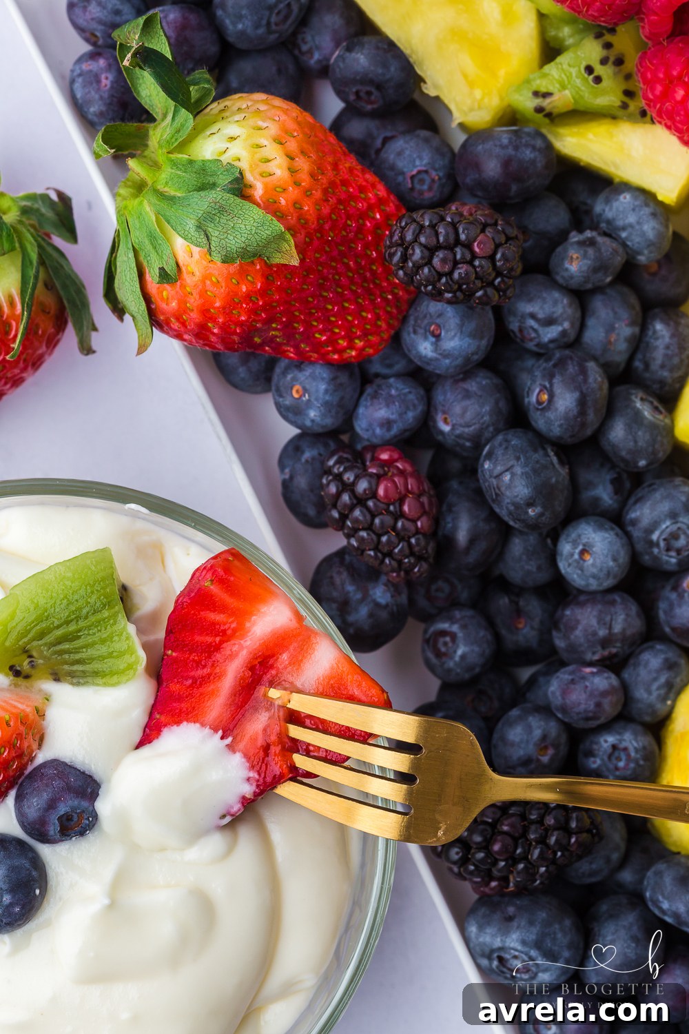 Luscious Fruit Dip 7 A serving bowl of creamy fruit dip surrounded by a colorful assortment of fresh fruit.