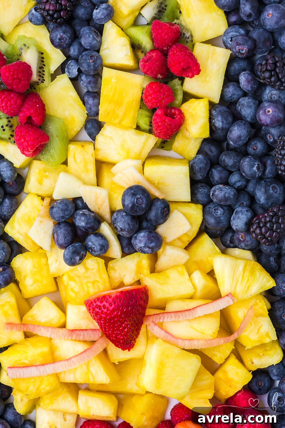 Colorful Easter Fruit Medley 3 Close-up of a colorful Easter Fruit Platter shaped like a bunny, featuring an assortment of fresh berries, kiwi slices, and pineapple chunks.
