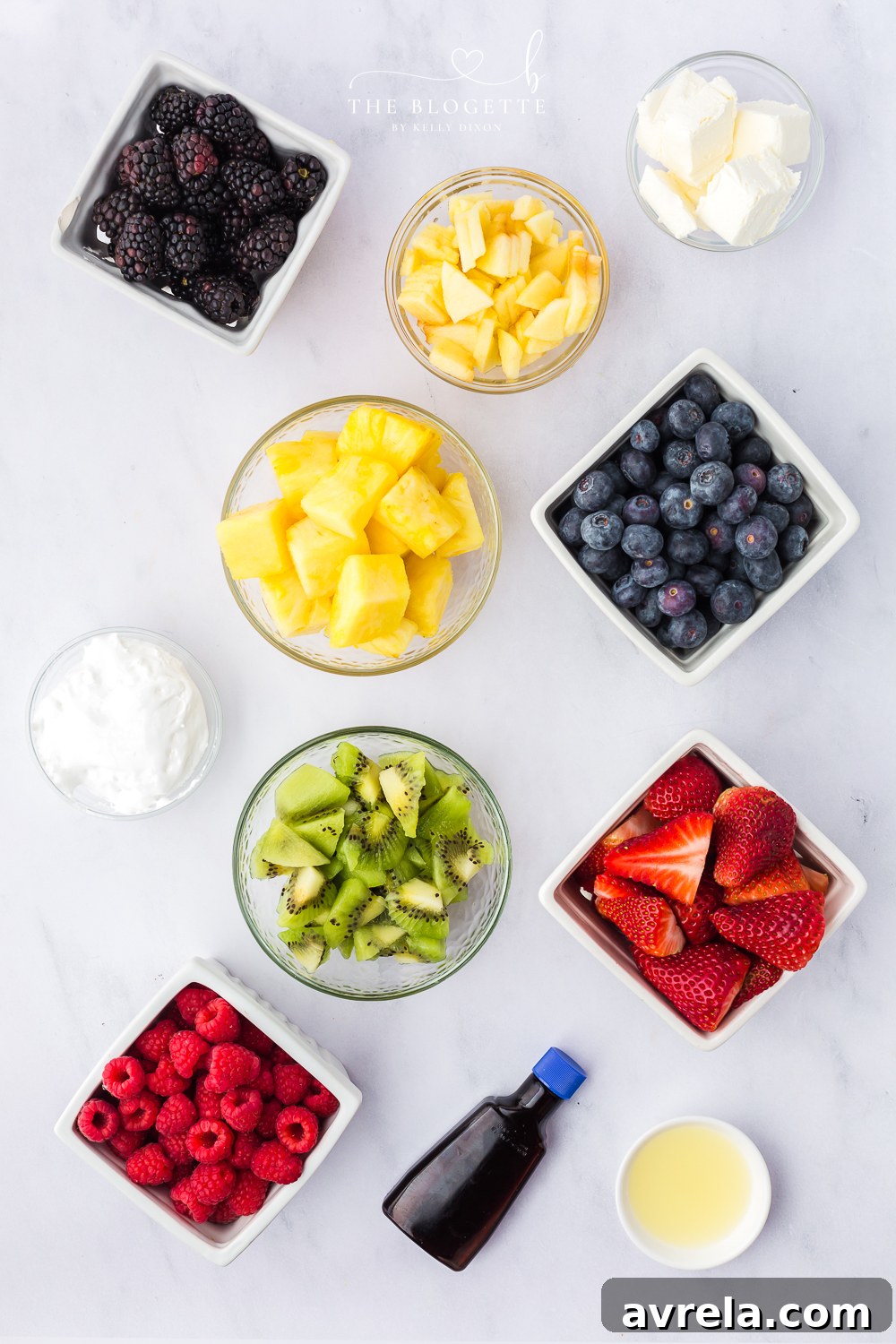 Colorful Easter Fruit Medley 4 All the fresh ingredients laid out for an Easter Fruit Platter, including pineapple, berries, kiwi, and apple, plus cream cheese, marshmallow fluff, and almond extract for the dip.