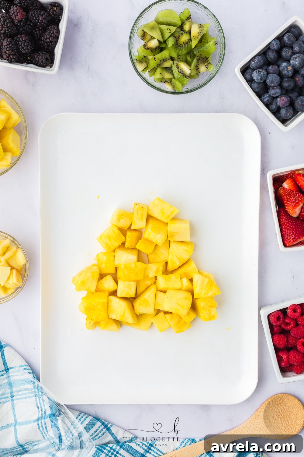 Colorful Easter Fruit Medley 5 First steps of assembling the fruit on a platter, showing pineapple chunks being arranged.