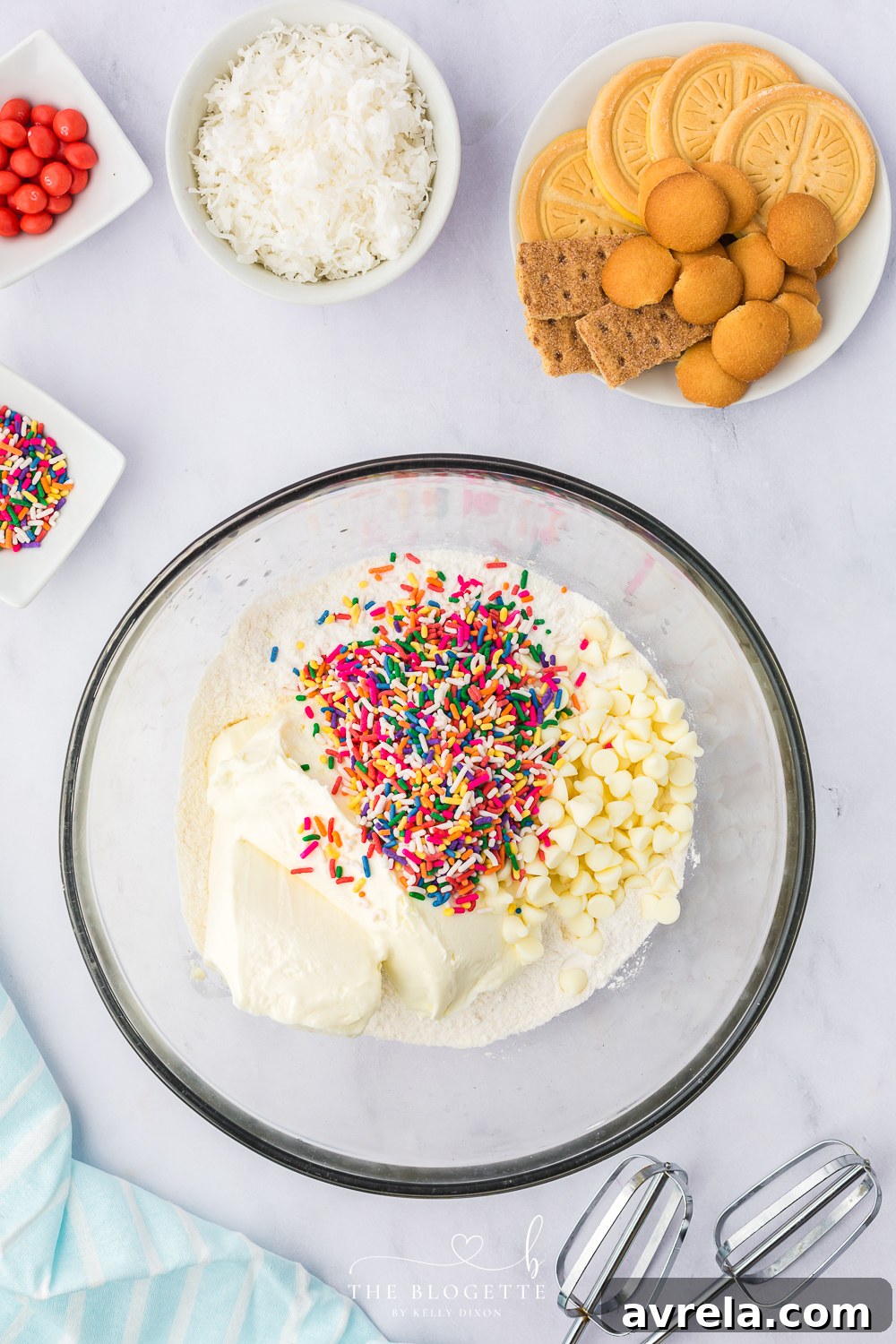 Mixing the cream cheese, white chocolate chips, sprinkles, cake mix, and almond extract in a large bowl with an electric mixer for the Bunny Butt Cheeseball base.