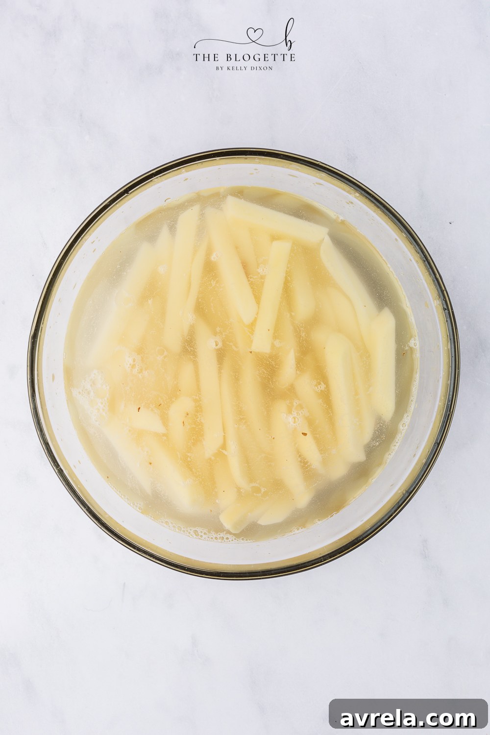 Place the potato slices in a large bowl with water