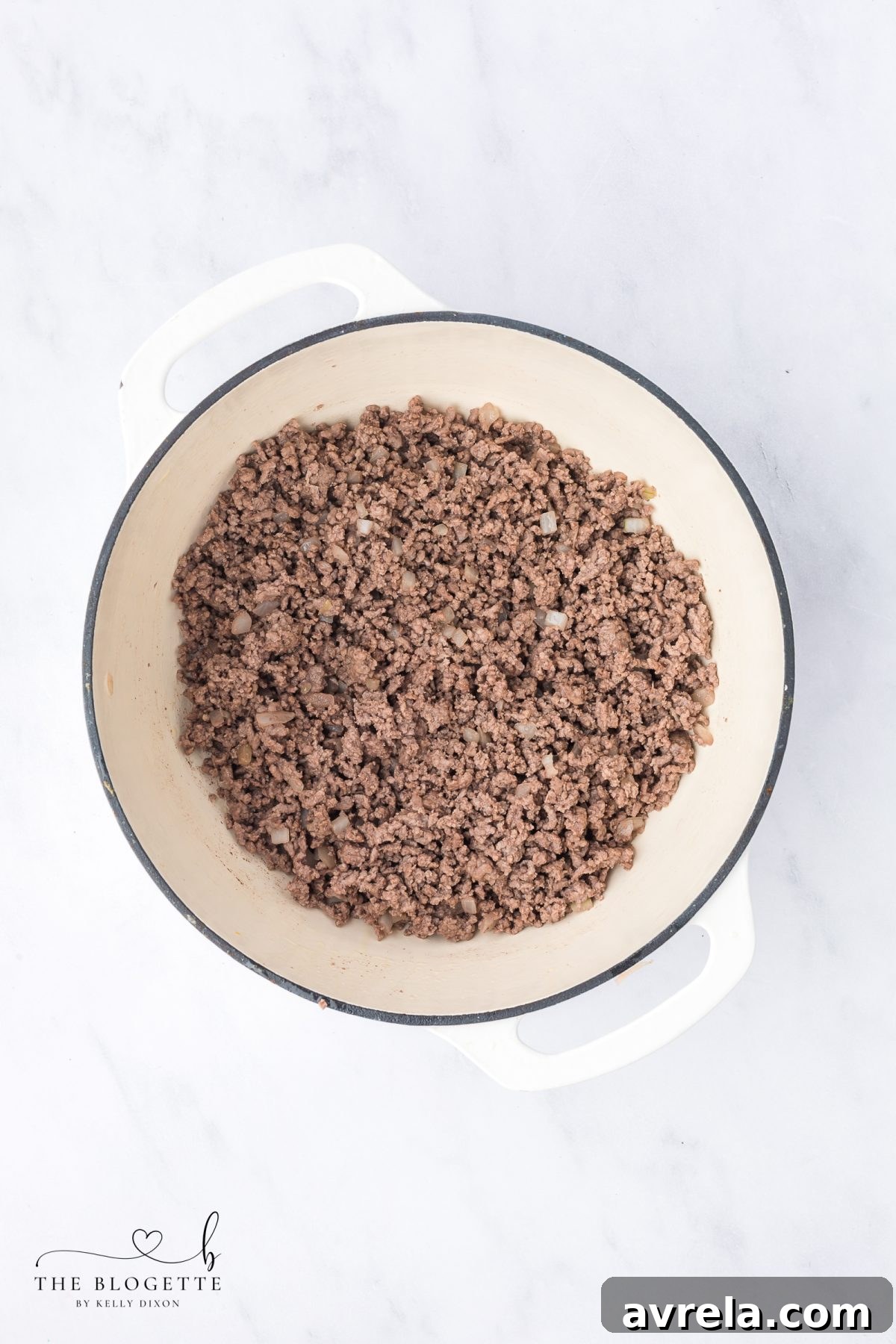 Brown ground beef in a large pot after sautéing onions for taco spaghetti.