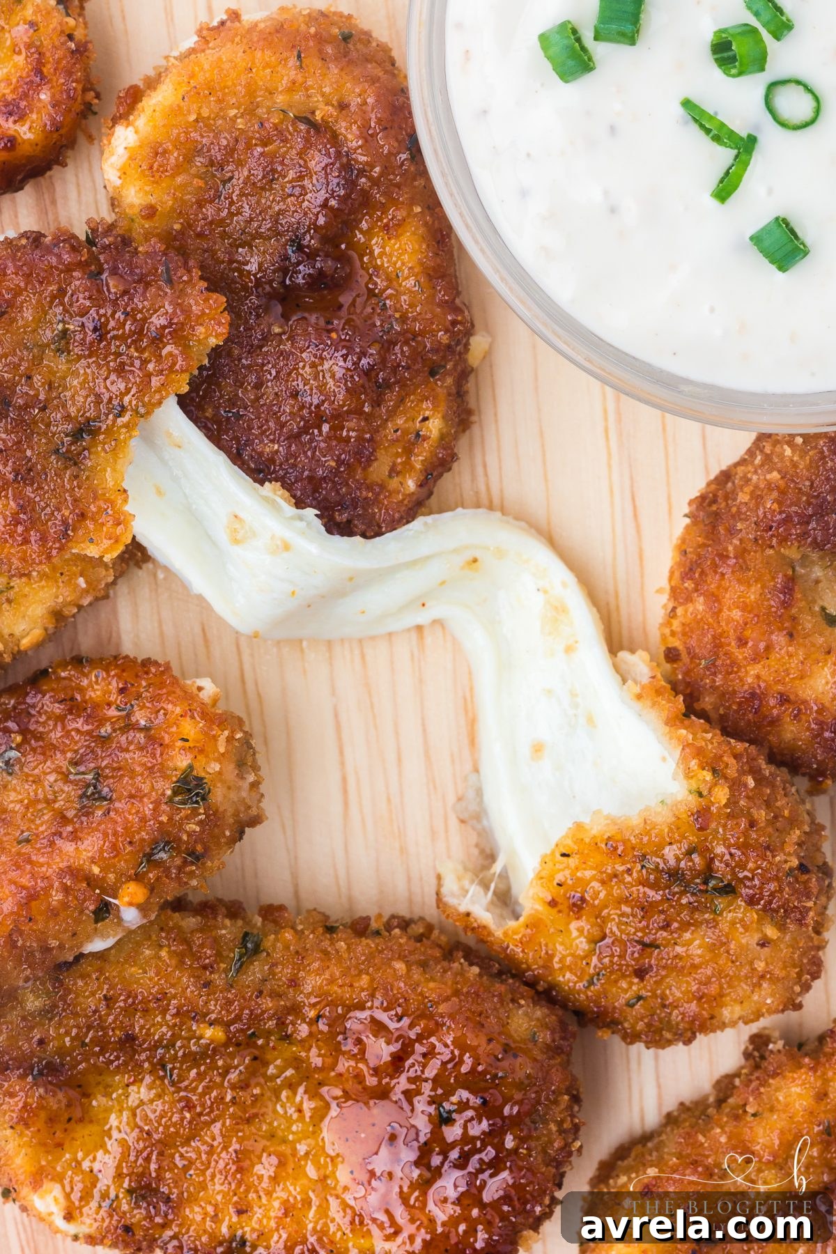 Two Nashville Hot Mozzarella Sticks displayed on a white surface, showcasing their golden-brown crust and spicy coating.