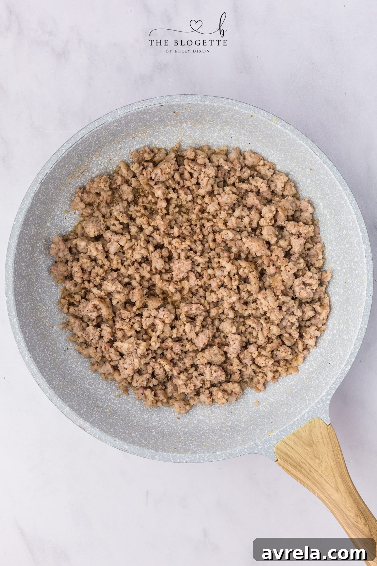 Rise and Shine Pizza 6 Browning breakfast sausage in a skillet, breaking it into crumbles as it cooks.