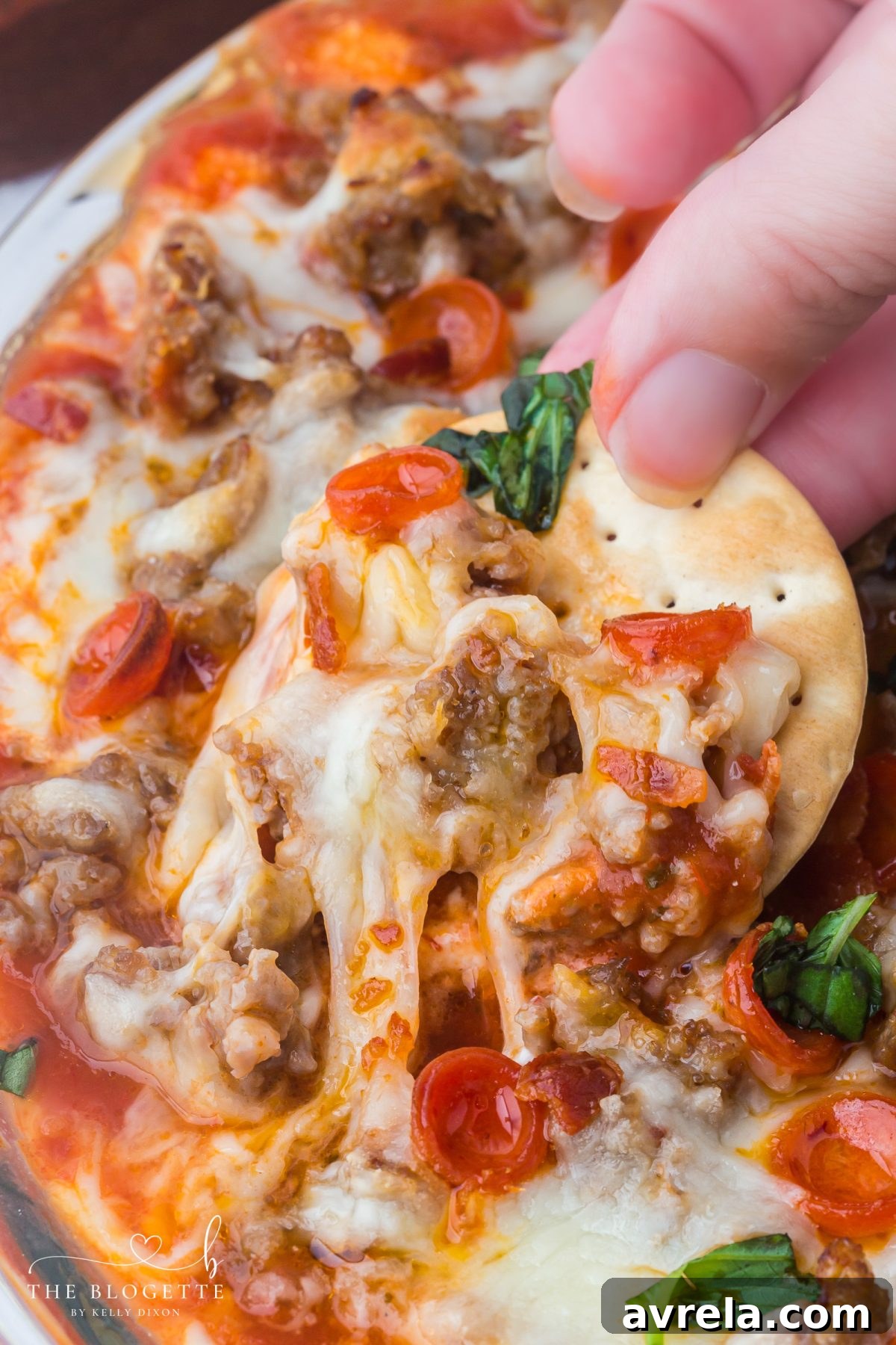 This easy Pizza Dip recipe is loaded with cream cheese, Italian sausage, mozzarella, and mini pepperonis for a gooey, crowd-pleasing appetizer everyone will love.
