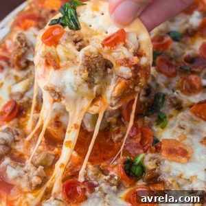This easy Pizza Dip recipe is loaded with cream cheese, Italian sausage, mozzarella, and mini pepperonis for a gooey, crowd-pleasing appetizer everyone will love.