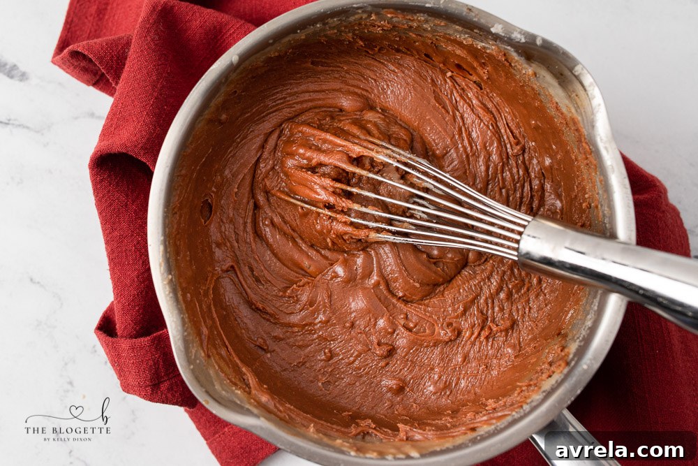 Two distinct layers of chocolate and peanut butter fudge in a baking pan, cooling