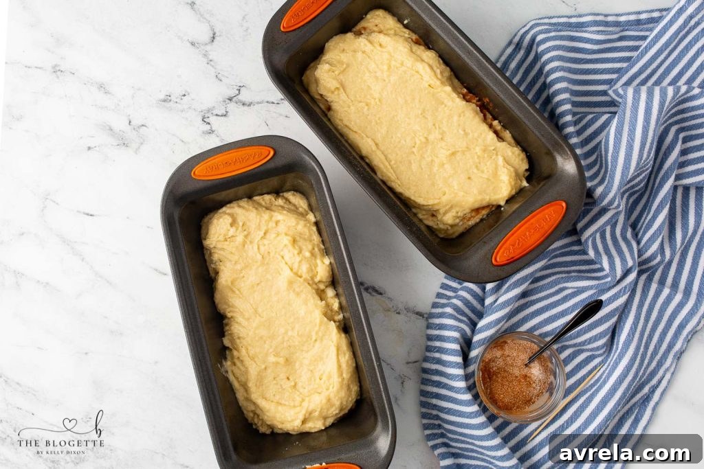 Layering the Amish Cinnamon Bread batter and cinnamon-sugar mixture in loaf pans