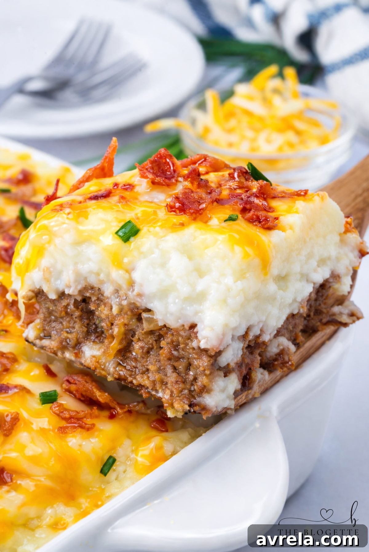 A perfectly baked Loaded Potato Meatloaf Casserole, showcasing its bubbling cheese topping and golden edges, ready to be served.