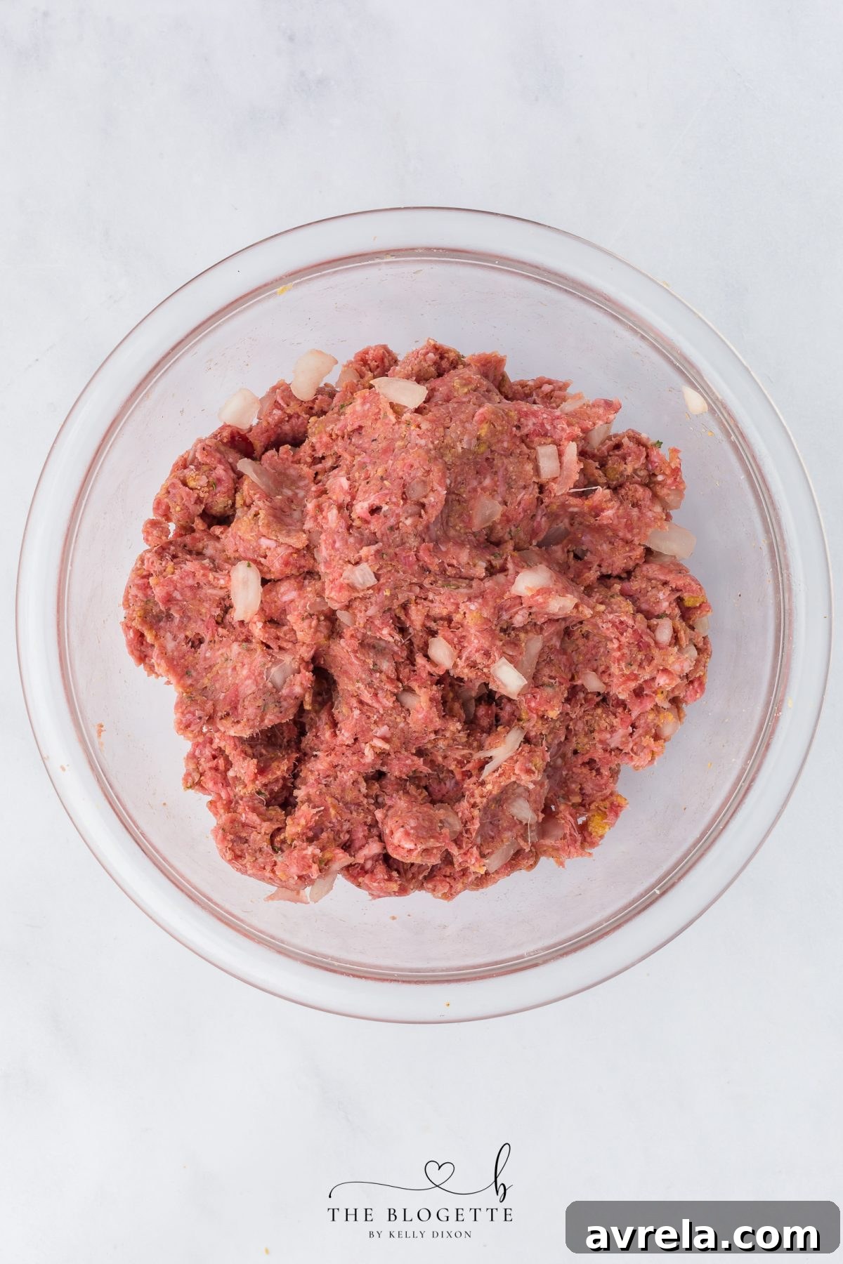 Gently mixing the breadcrumbs and egg into the meatloaf mixture until just combined, ensuring a tender texture.
