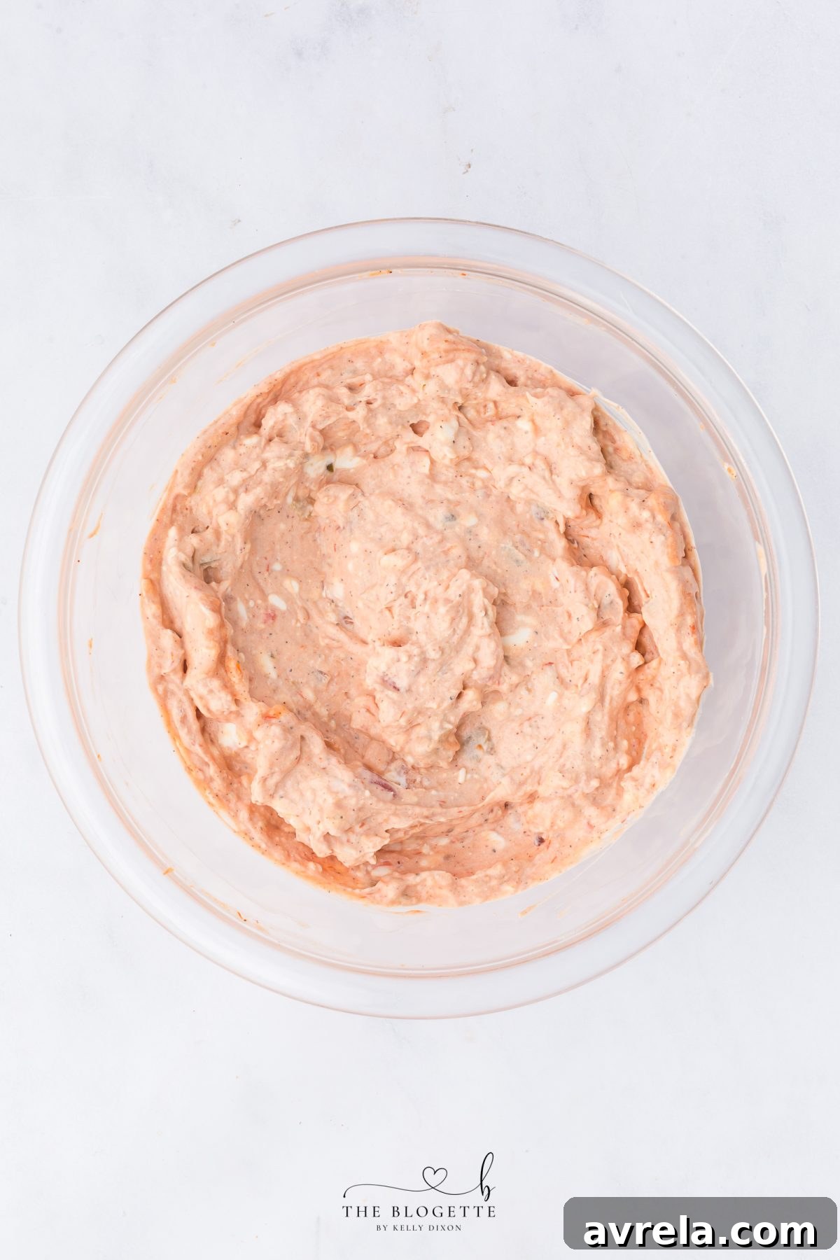 A spatula mixing the creamy sauce ingredients in a bowl, showing a smooth consistency.