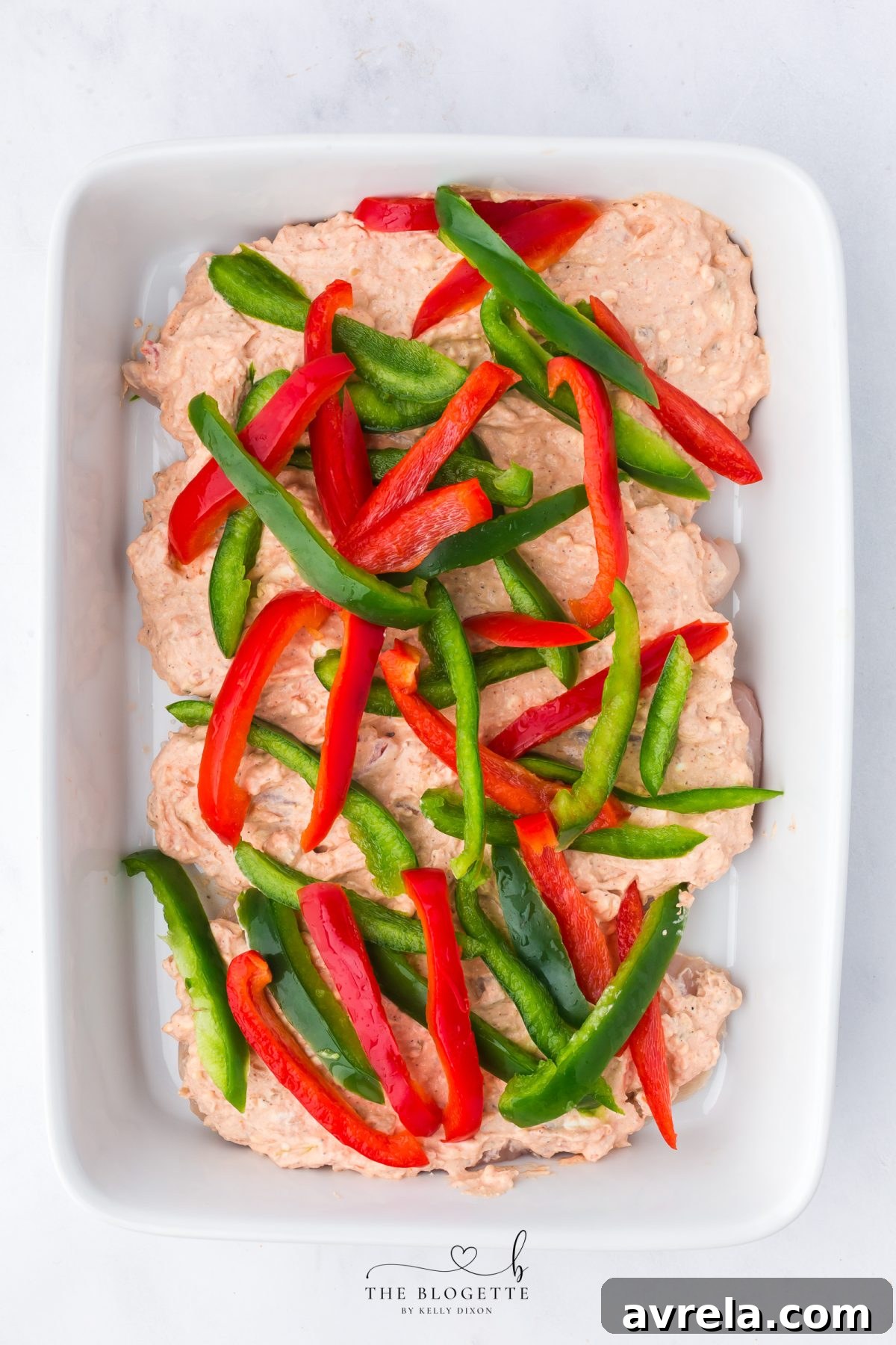 The chicken fajita casserole assembled with bell peppers on top, ready for baking.