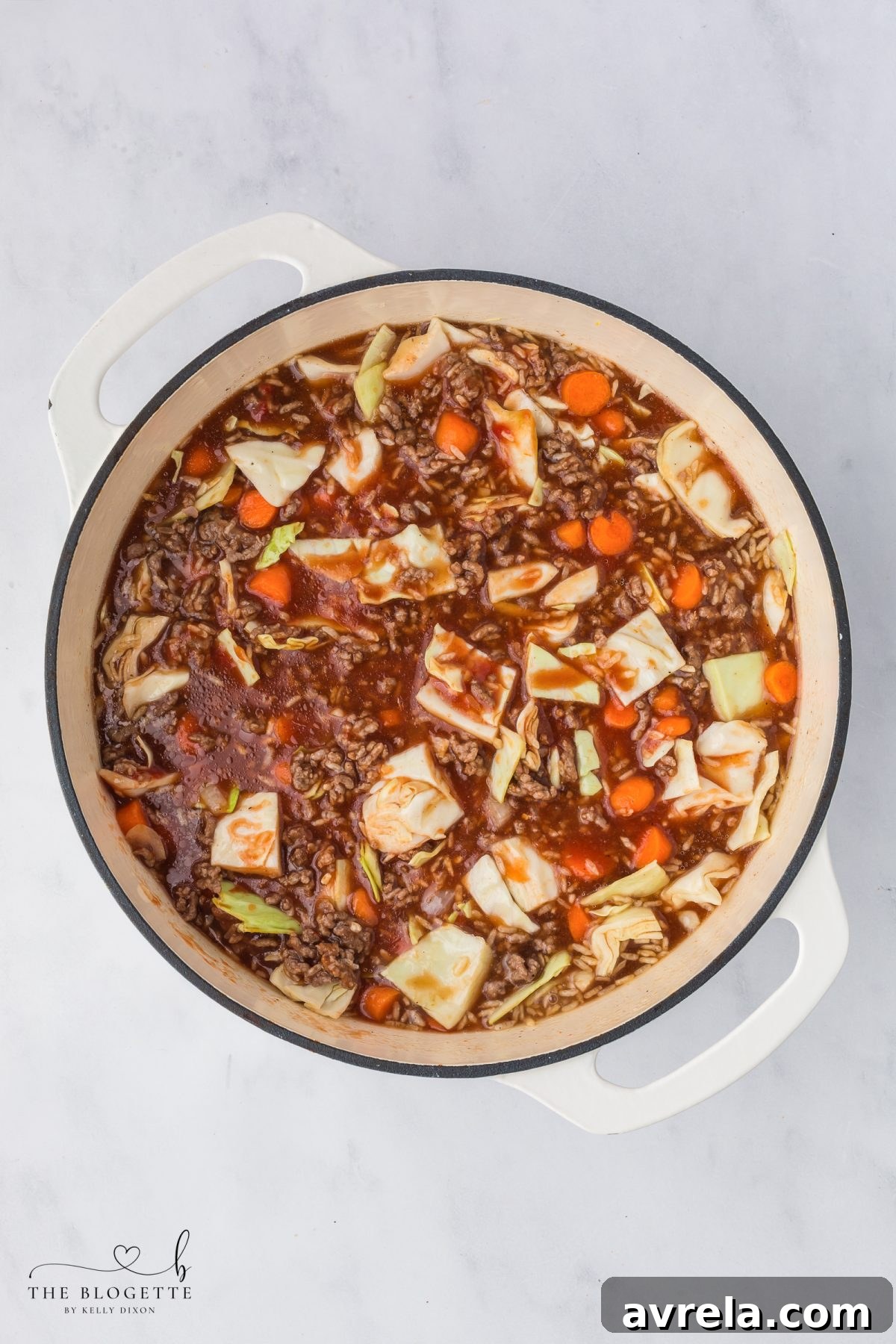The cabbage soup mixture stirred together before simmering, showing the rich blend of ingredients.