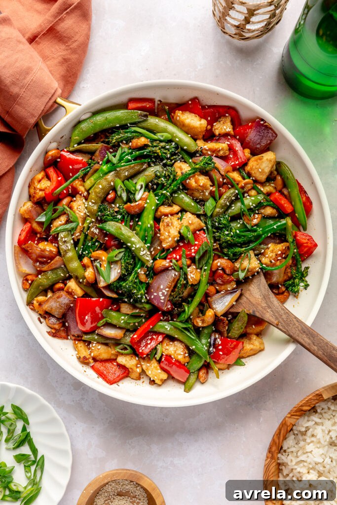 Vibrant Asian cashew chicken stir-fry skillet with tender chicken, crunchy vegetables, and toasted cashews, ready to serve.