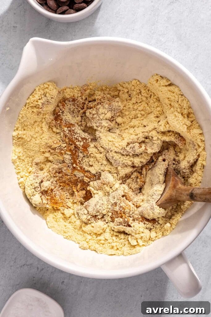 Stirring peanut butter mixture into dry ingredients for protein bars