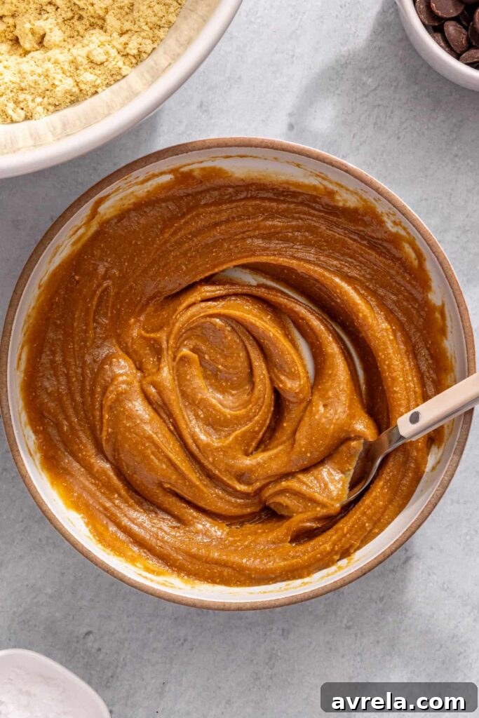 Mixing peanut butter, honey, and almond milk until smooth