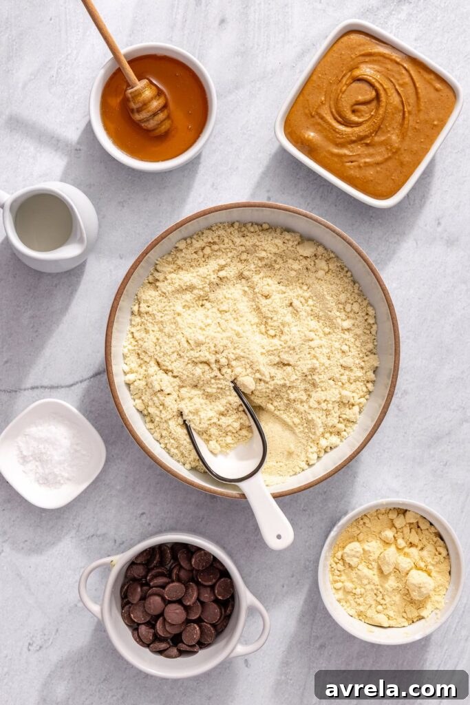 overhead shot of almond flour, peanut butter, honey, protein powder, and chocolate chips to make no-bake protein bars