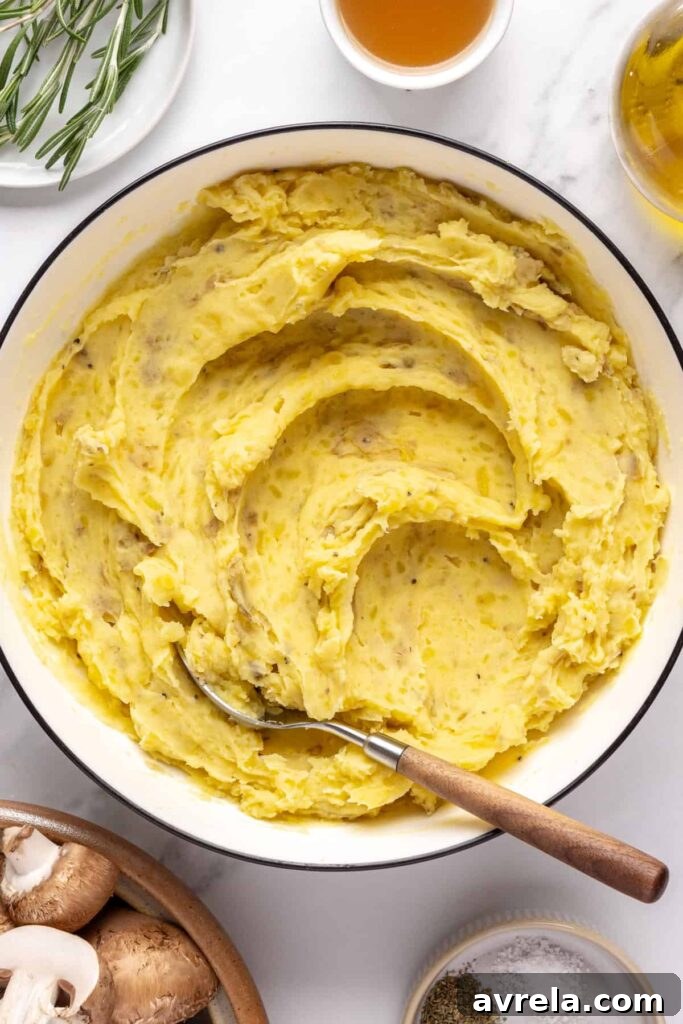 Creamy mashed mini potatoes with almond milk, ghee, and garnished with chives and olive oil
