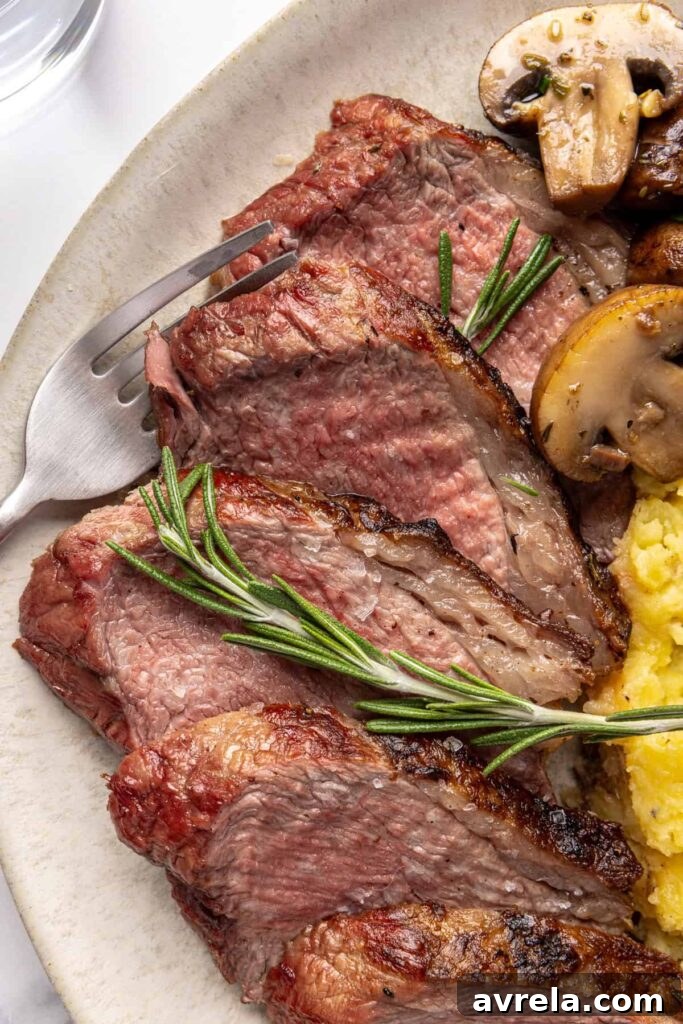 close-up of tri-tip steak served with creamy mashed potatoes and garlicky mushrooms on a dinner plate