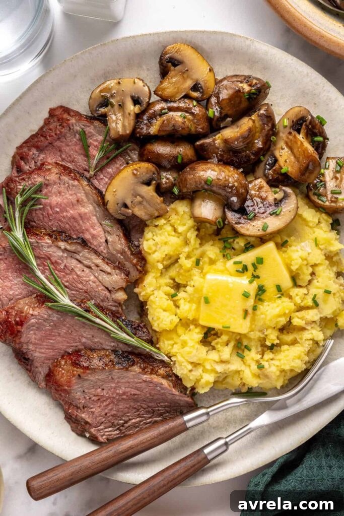 Steakhouse-style tri-tip steak dinner with mashed potatoes and sautéed garlic mushrooms, plated for serving