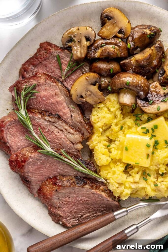Steakhouse-style tri-tip steak dinner with mashed potatoes and sautéed garlic mushrooms, plated for serving