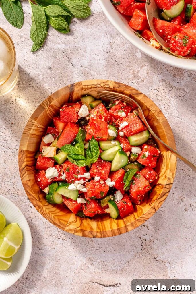 Bowl of watermelon salad with feta cheese and sliced cucumbers