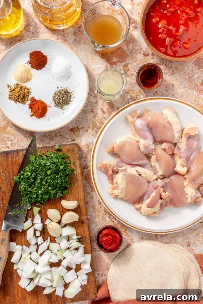 Ingredients for crockpot chicken tinga including chicken thighs, tomatoes, garlic, and spices