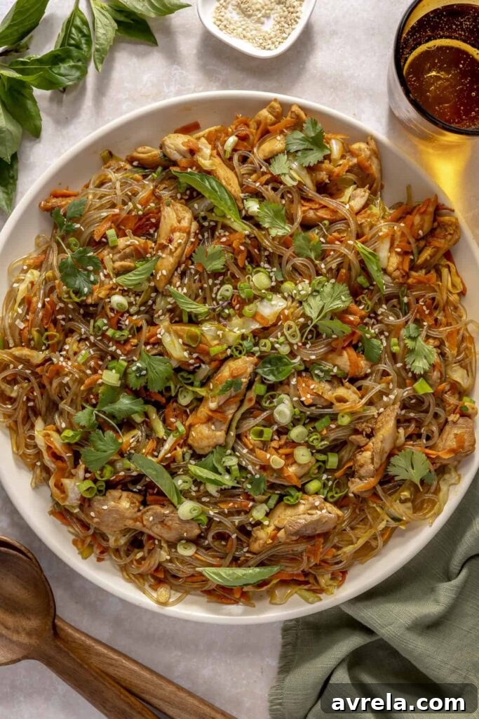 Sticky Honey-Garlic Chicken with Glass Noodles Recipe 17 Honey garlic chicken with glass noodles in a skillet, topped with green onions and sesame seeds