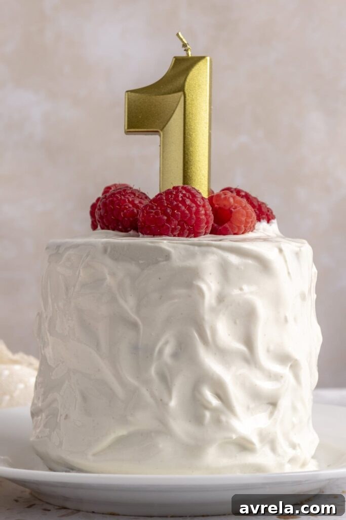Healthy first birthday smash cake with yogurt frosting and fresh berries on top