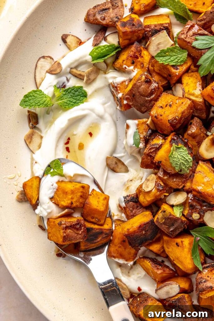 Maple-Roasted Sweet Potatoes with Whipped Feta and Hot Honey 2 Crispy roasted sweet potatoes on a plate with whipped feta, hot honey, and toasted almonds