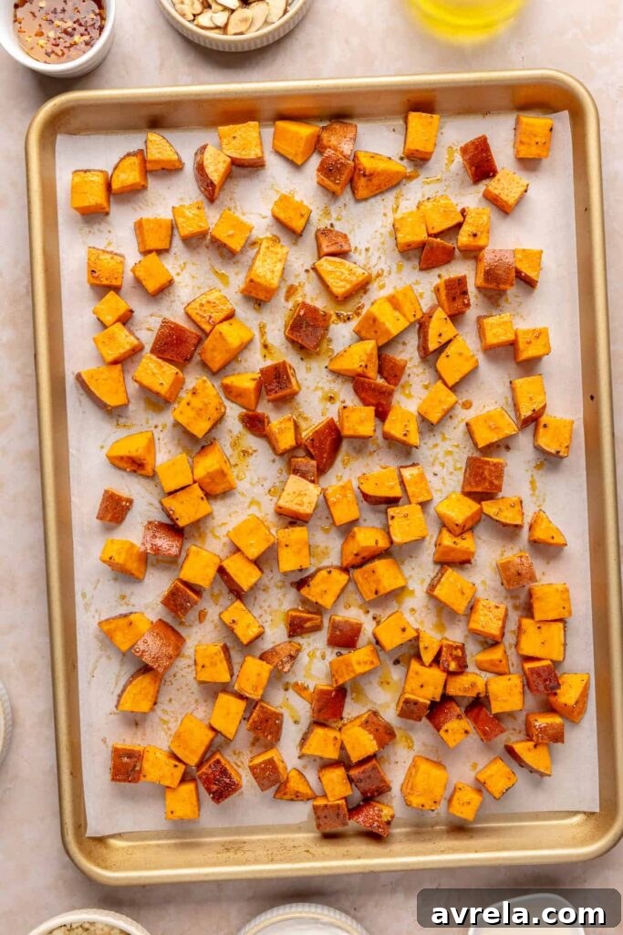Maple-Roasted Sweet Potatoes with Whipped Feta and Hot Honey 11 Sweet potatoes roasting on a parchment-lined baking sheet until golden brown