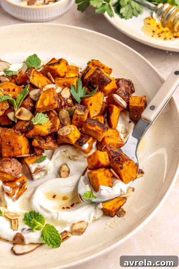 Maple-Roasted Sweet Potatoes with Whipped Feta and Hot Honey 17 Crispy roasted sweet potatoes on a plate with whipped feta, hot honey, and toasted almonds
