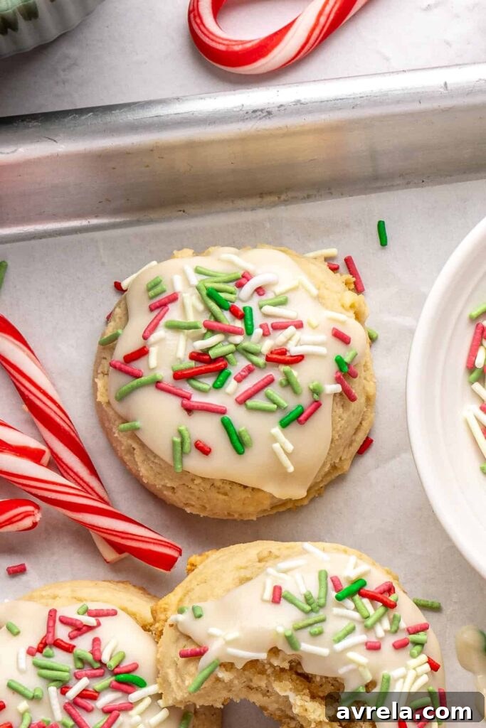 close-up of Gluten-free Christmas sugar cookies with creamy frosting and festive sprinkles on a styled baking sheet