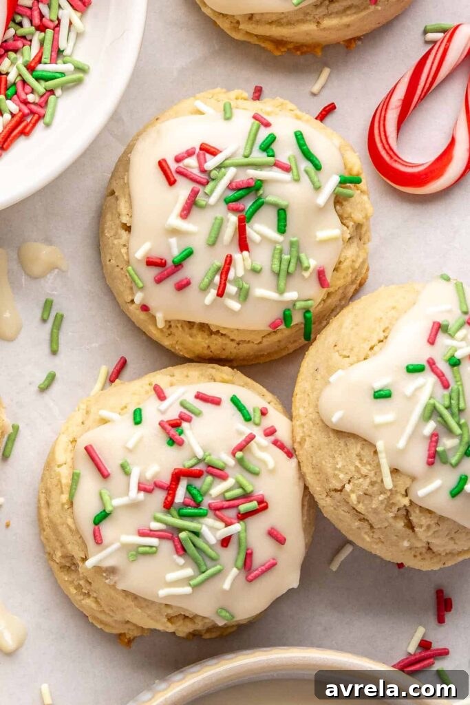 close-up of Gluten-free Christmas sugar cookies with creamy frosting and festive sprinkles on a styled baking sheet