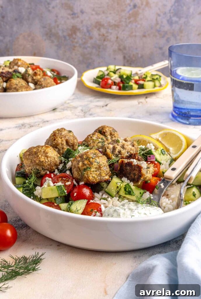 Juicy Greek turkey meatballs served over rice with tzatziki and cucumber-tomato salad.