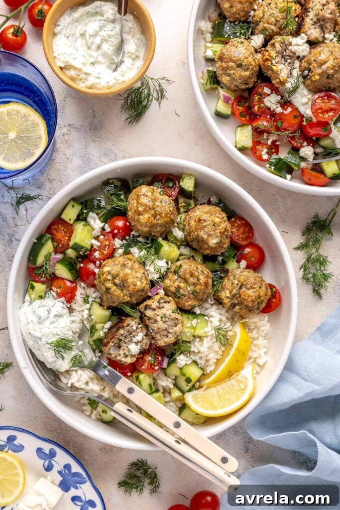 Greek turkey meatball bowl with rice, cucumber salad, and tzatziki.