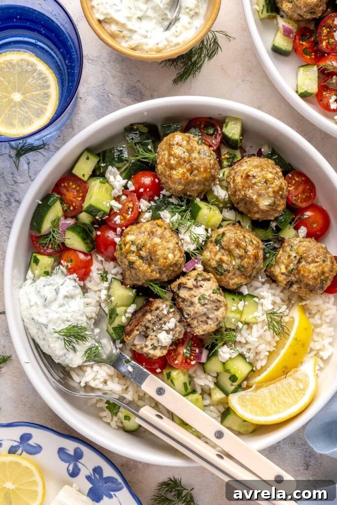 Juicy Greek turkey meatballs served over rice with tzatziki and cucumber-tomato salad.