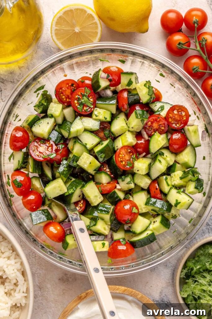 Fresh cucumber-tomato salad tossed with olive oil, red wine vinegar, and herbs.